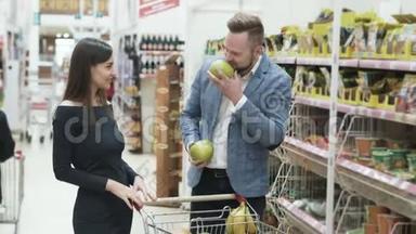 正面视频年轻夫妇，女人在超市用水果做滑稽的脸